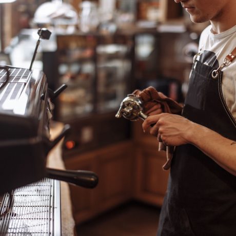 a waiter is drying the coffee grinder after washing waiter is drying the coffee grinder after washing. side view cropped photo